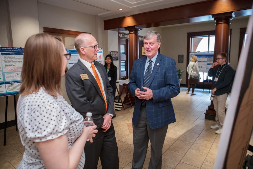 President T. Haas speaking to Doctor Potteiger at the Graduate showcase